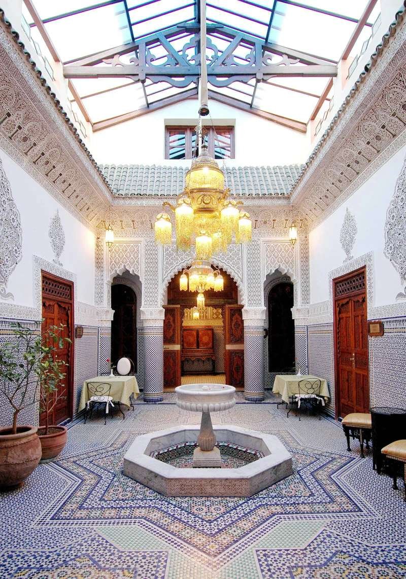 Traditional Moroccan riad courtyard with zellige fountain showing quality architectural restoration