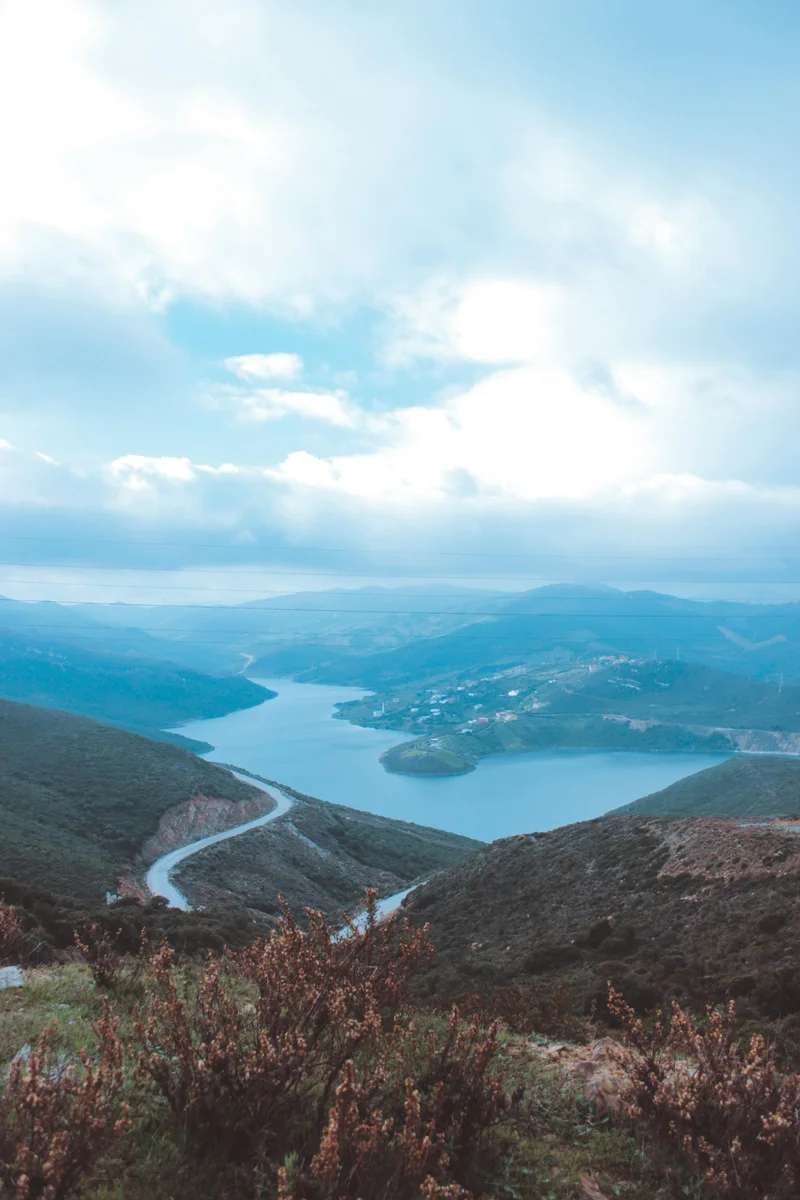 Scenic winding mountain road overlooking turquoise lake surrounded by hills in Morocco